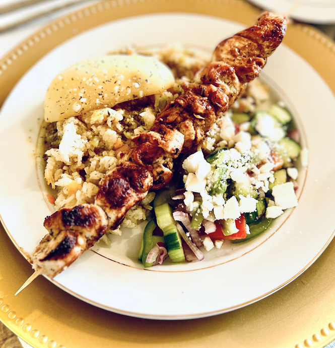 A plate of food with meat and vegetables on a table.