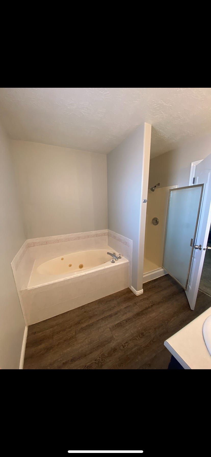 A bathroom with a jacuzzi tub and a walk in shower.