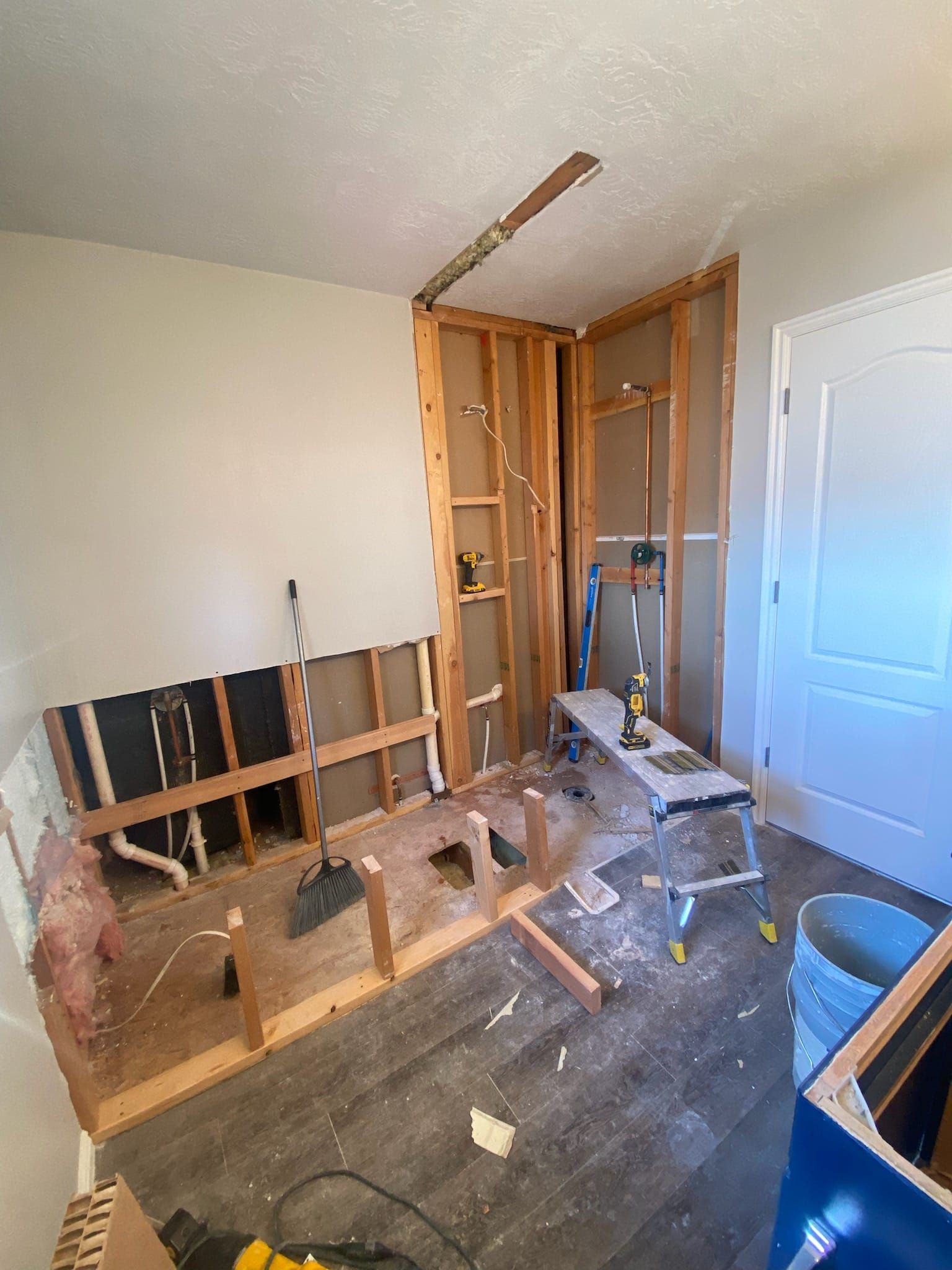 A room that is being remodeled with wooden walls and a ladder.