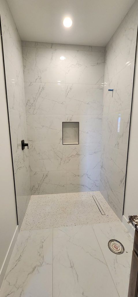 A bathroom with a walk in shower and a sink.