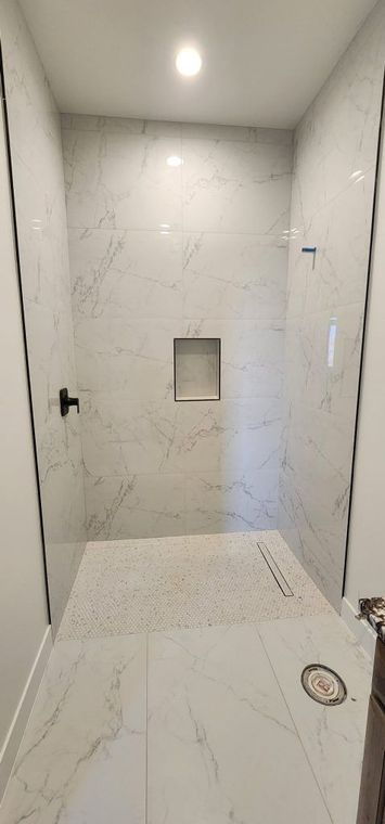 A bathroom with a walk in shower and a sink.