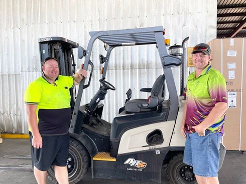 Two Staff Standing In Front of Forklift Truck — Trusted Carrier in Rockhampton & Gladstone, QLD