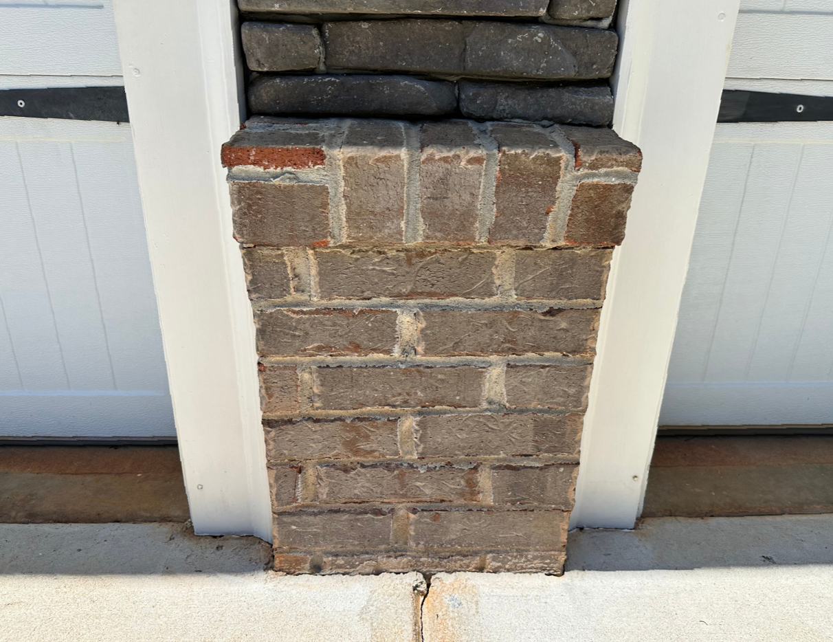 A close up of a brick wall next to a garage door