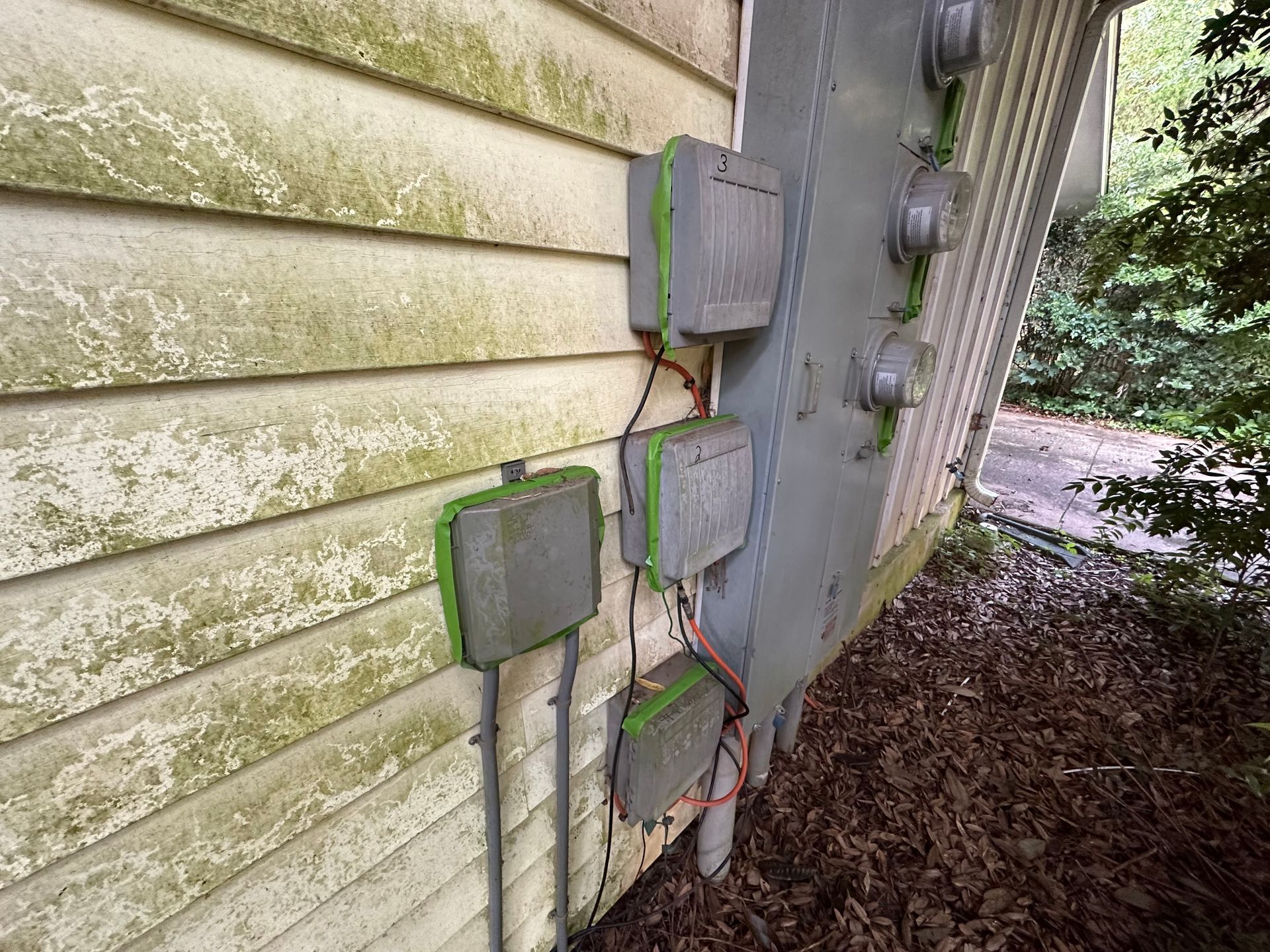 A house with a lot of electrical boxes on the side of it.