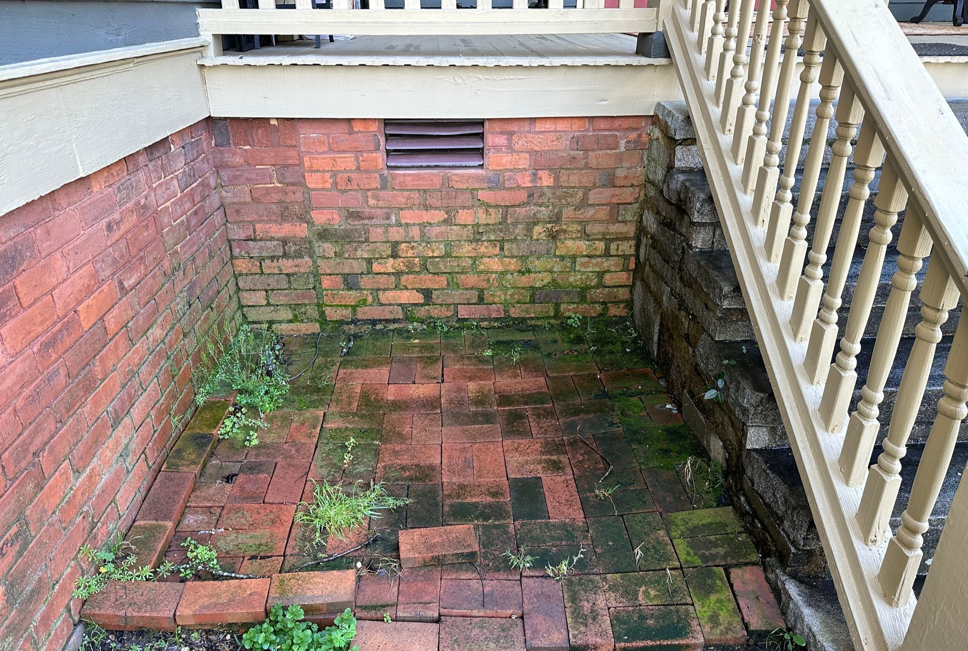 A brick walkway with stairs leading up to it and a brick wall behind it.