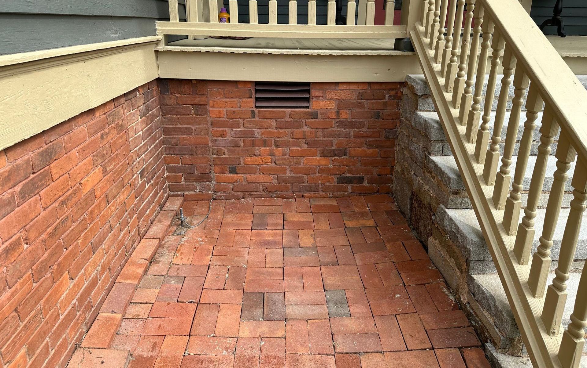 A brick walkway with stairs leading up to it and a brick wall.