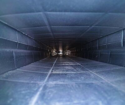 An air conditioner is sitting on the side of a brick house.