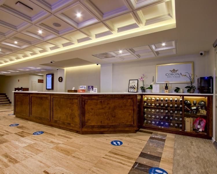 A hotel lobby with a long wooden counter and a wine rack.