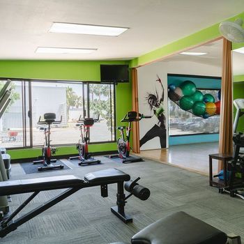 A gym with green walls and a picture of a woman on the wall