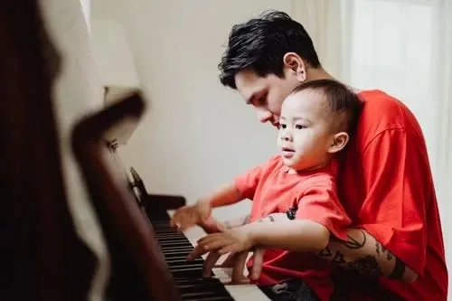 father and son playing piano