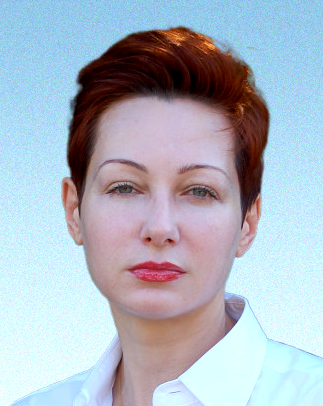 A woman with short red hair is wearing a white shirt.