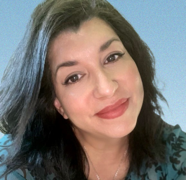 A woman with long black hair is smiling for the camera.