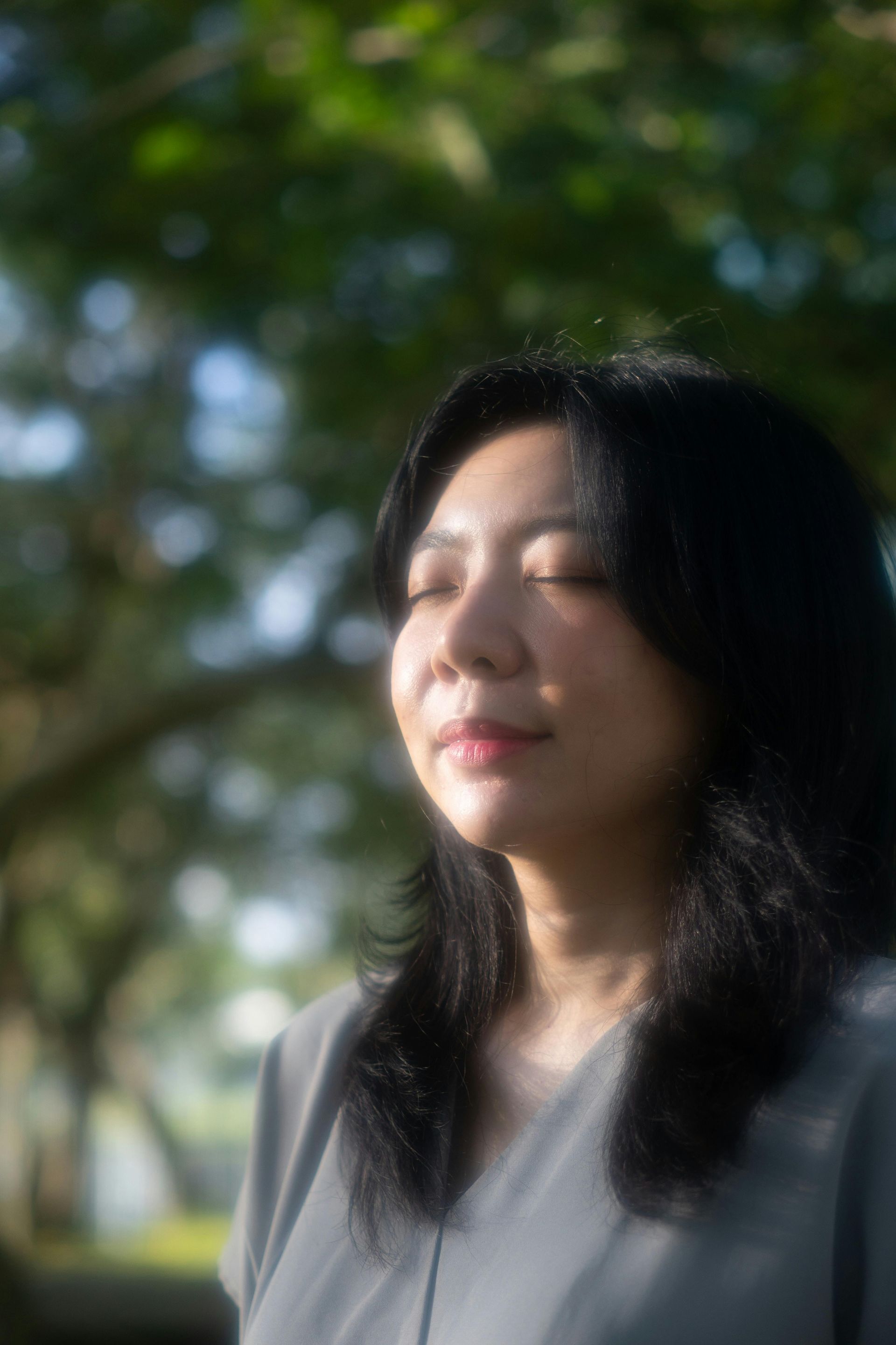 An Indian woman in a saree is standing in the woods.