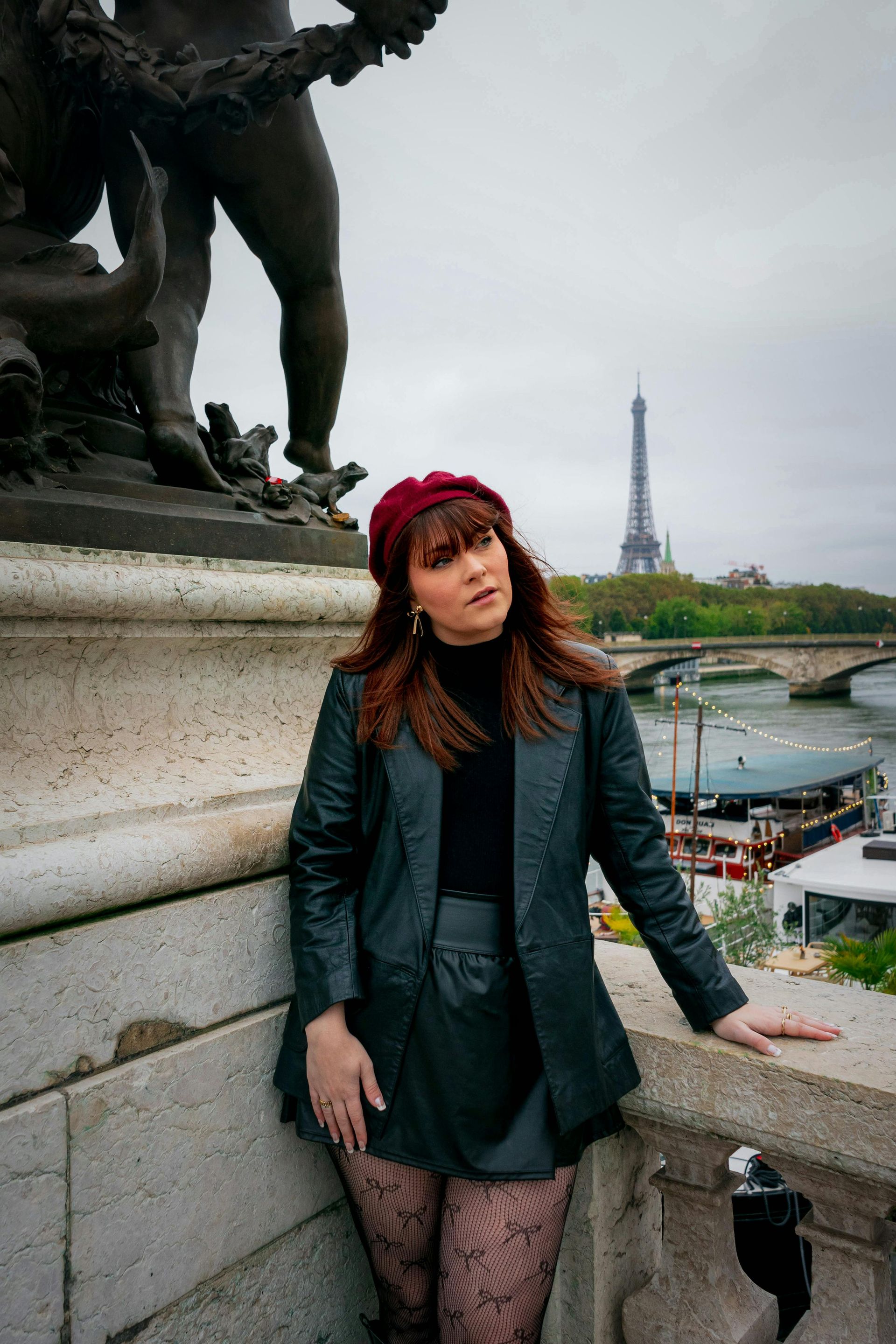 A black woman with braids in her hair is touching her face.