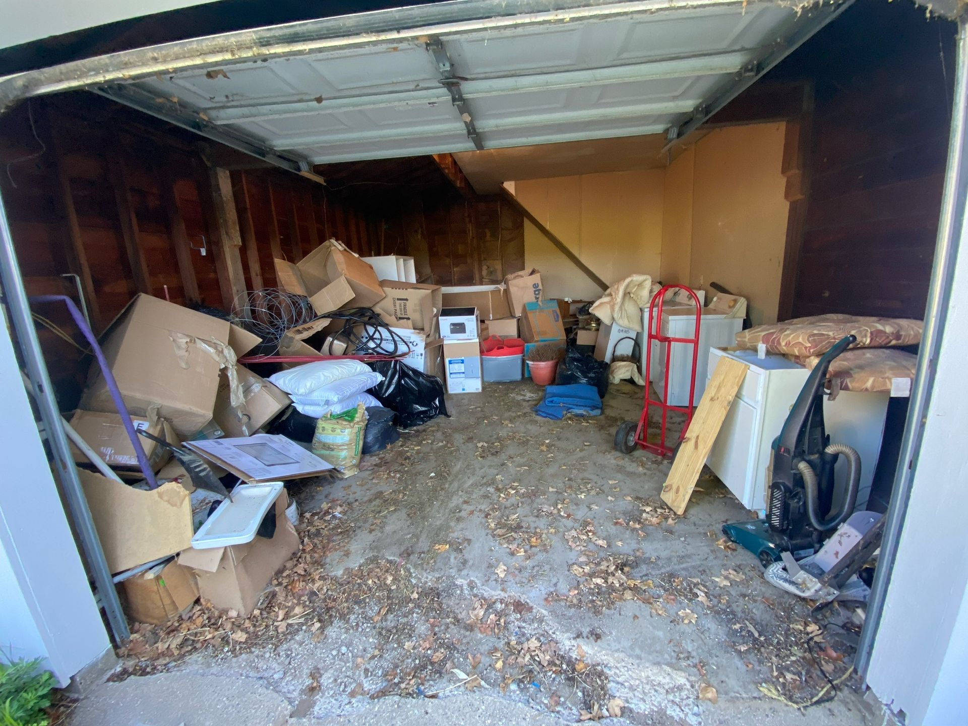 A garage filled with lots of boxes and trash