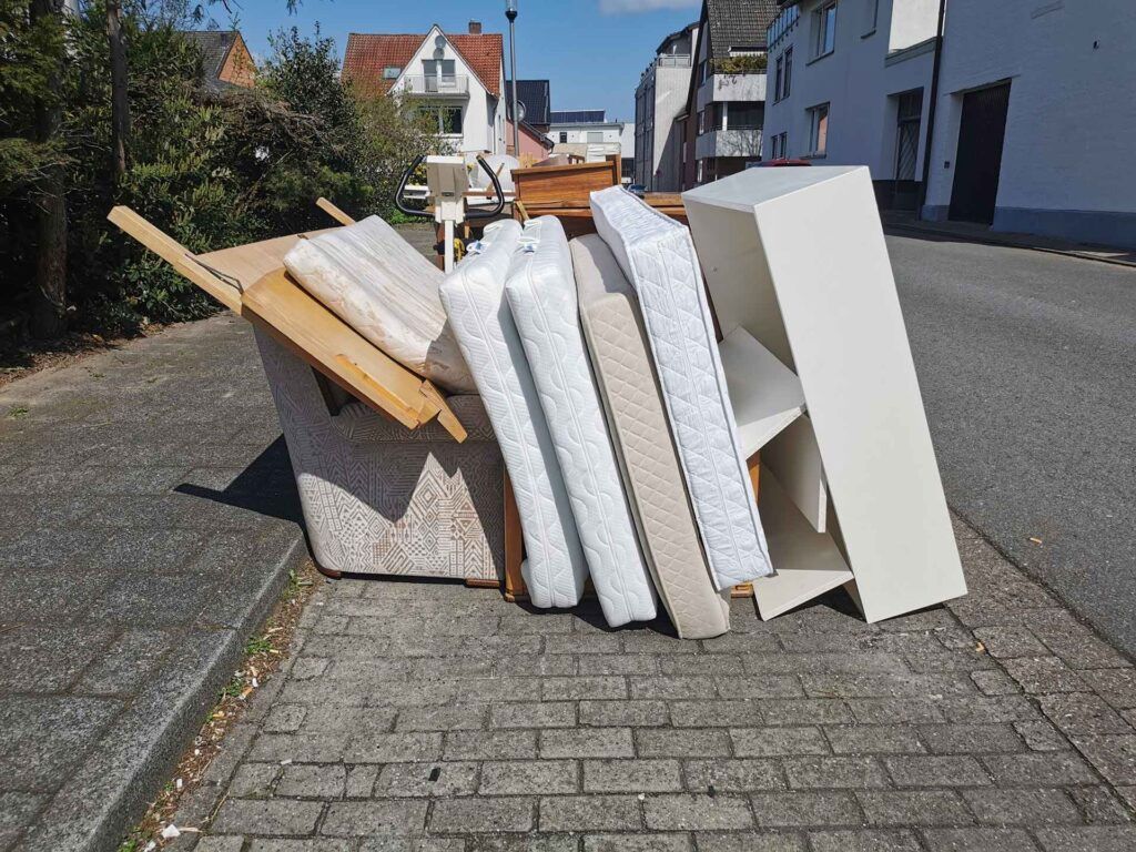 A pile of furniture is sitting on the side of the road.