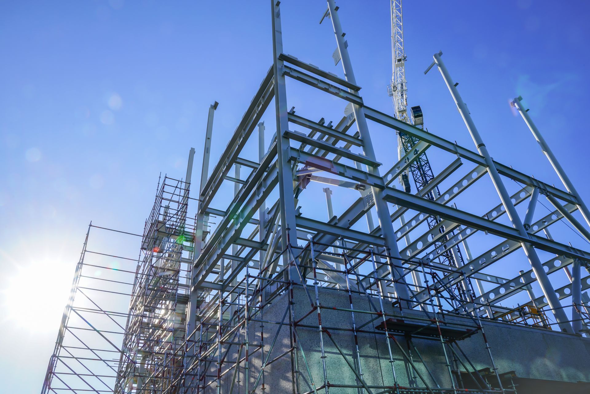 Steel framework of a building under construction with scaffolding against a clear sky. Steel framework of a building under construction with scaffolding against a clear sky.