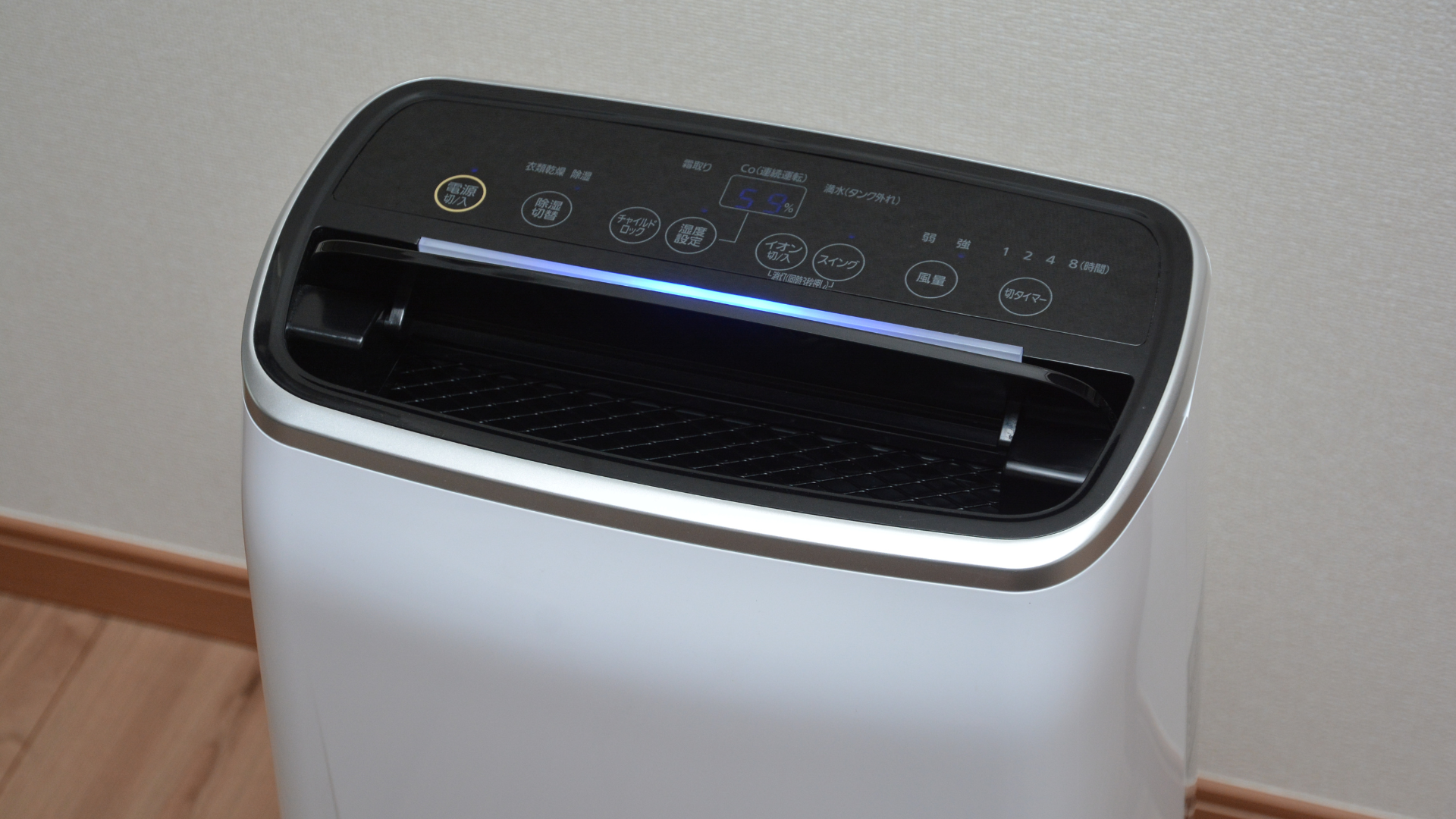 White air purifier with a black top and control panel.