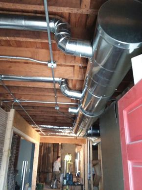 HVAC ductwork installed on a ceiling during a renovation. Exposed wooden beams and electrical conduits visible.