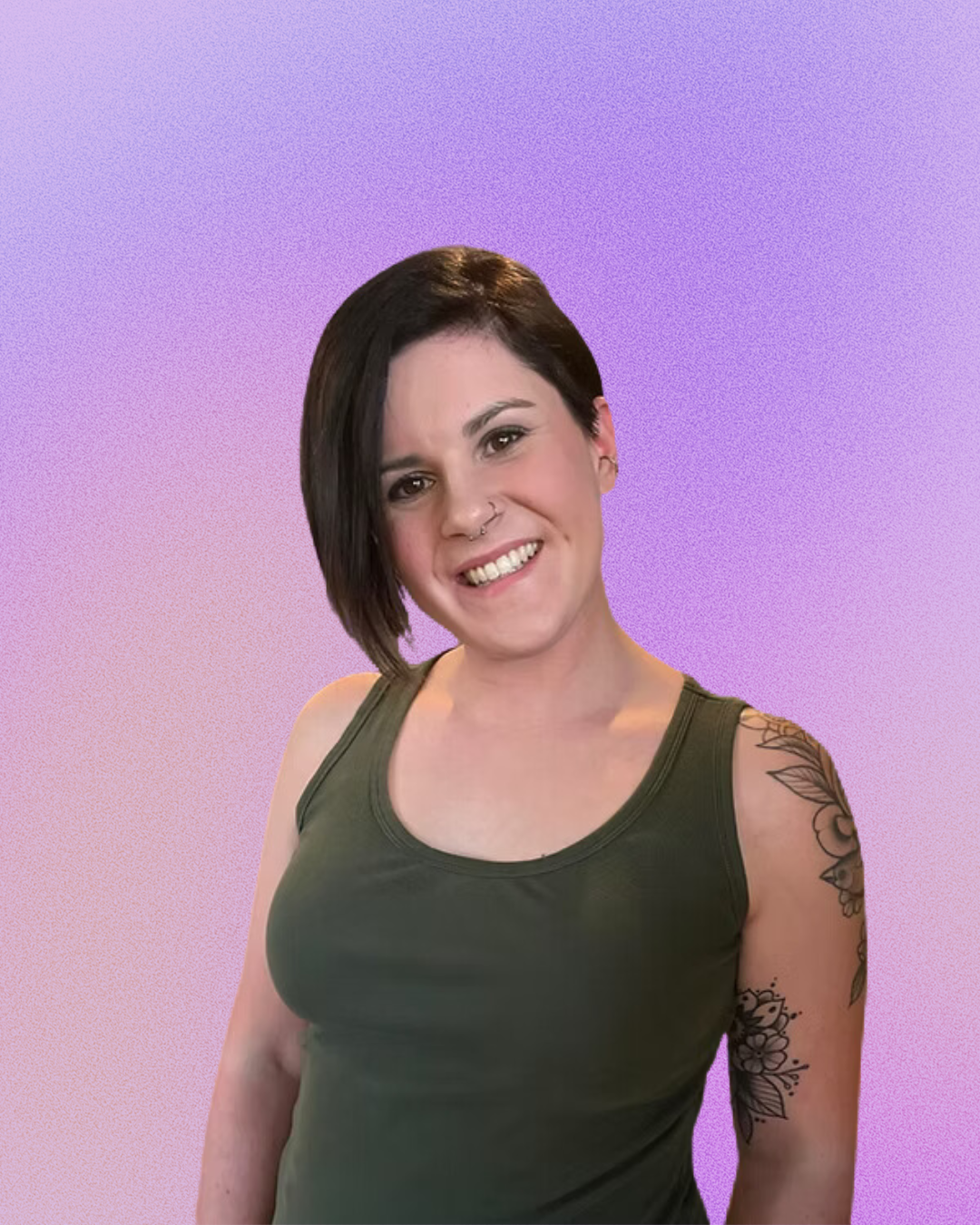 A woman with a tattoo on her arm is smiling and wearing a green tank top