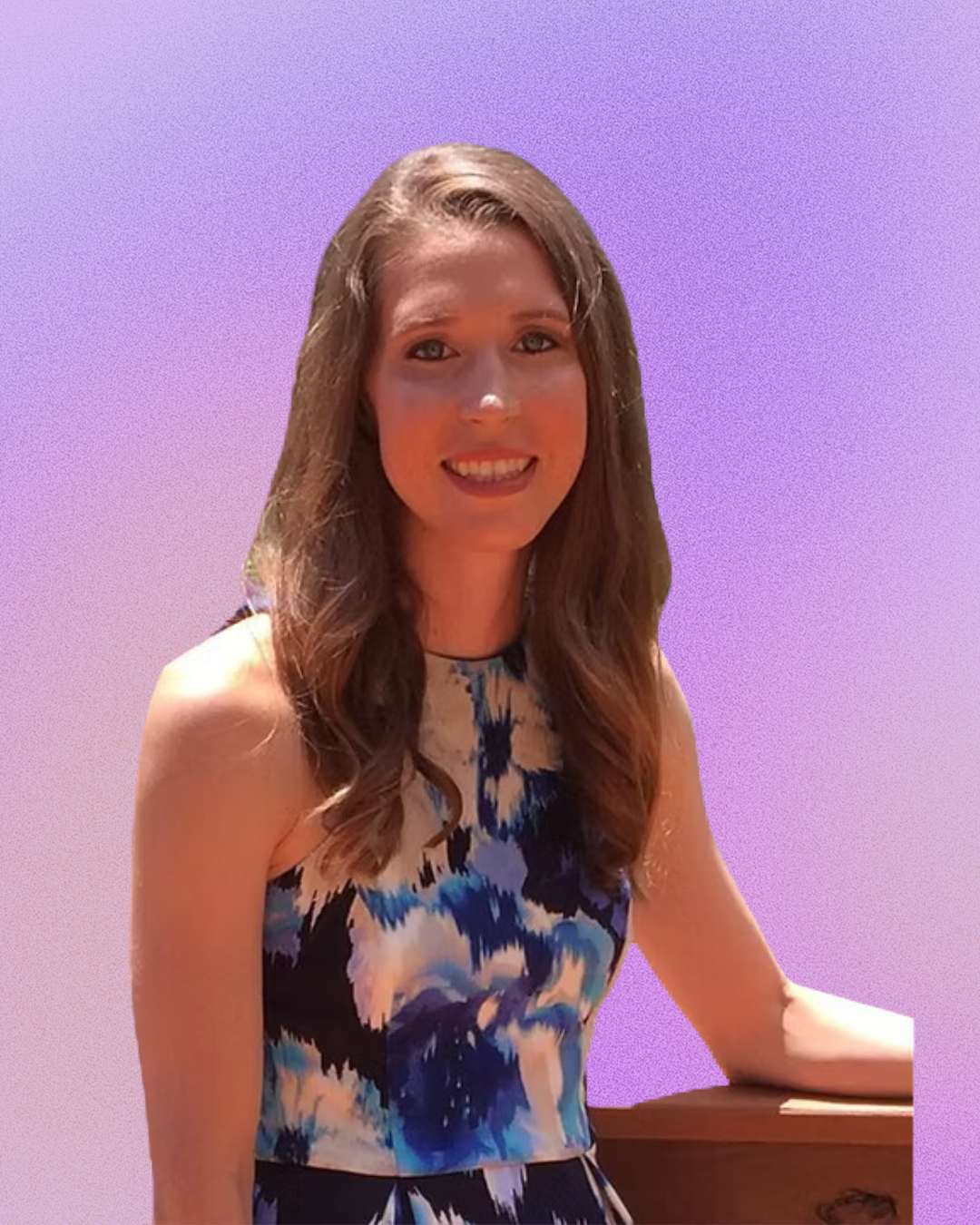 A woman in a floral dress is smiling in front of a purple background