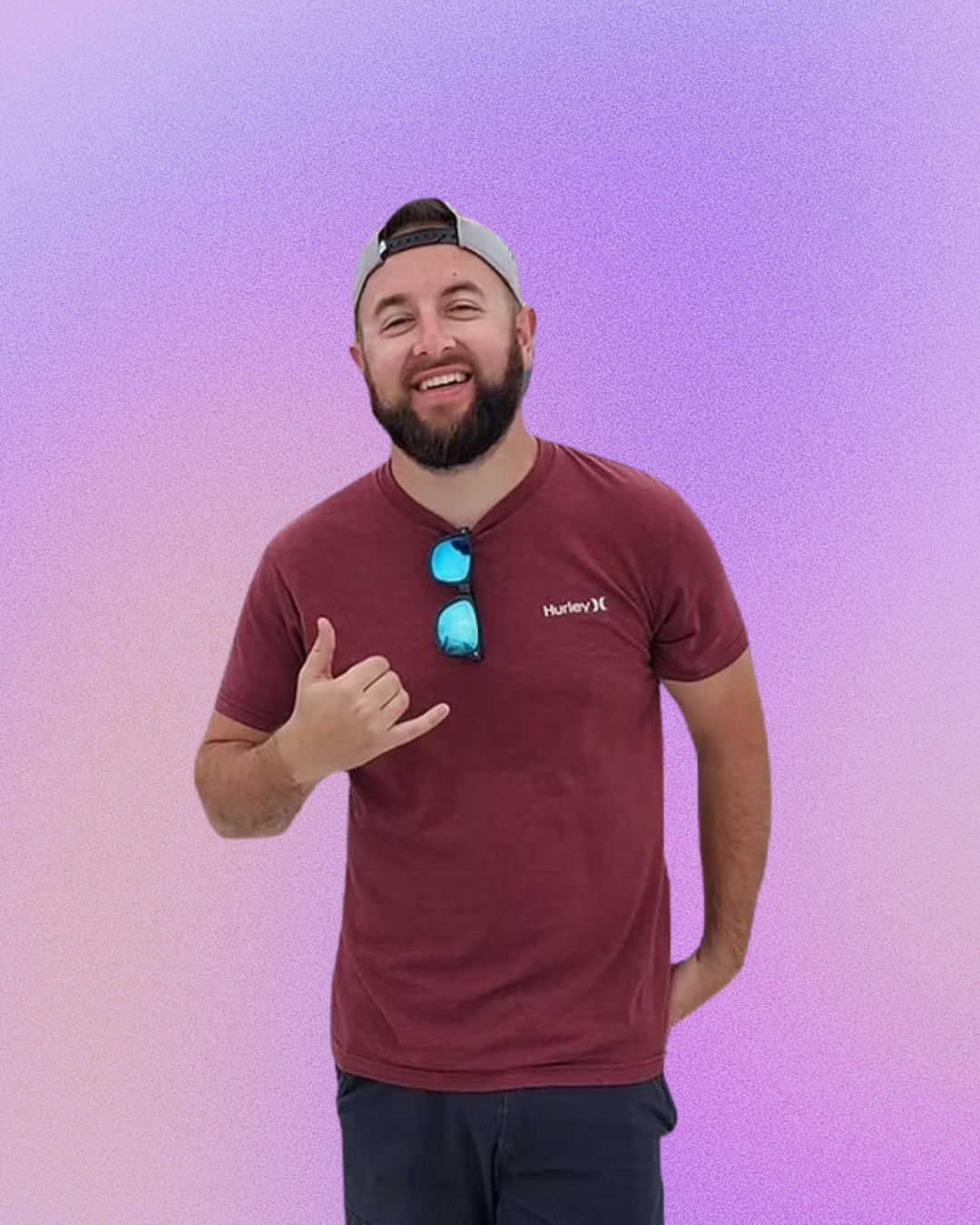 A man with a beard is wearing a maroon shirt and sunglasses.