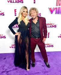 A man and a woman are standing next to each other on a purple carpet.