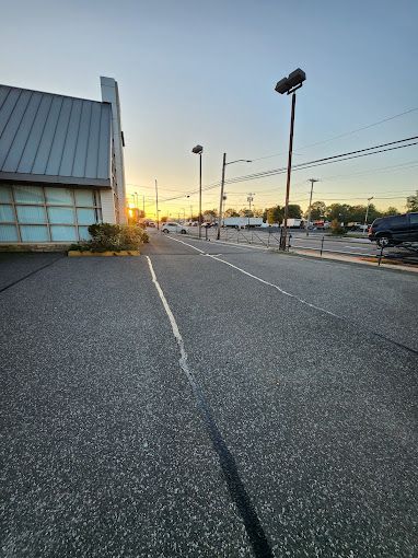 A road with a building in the background and a lot of street lights.