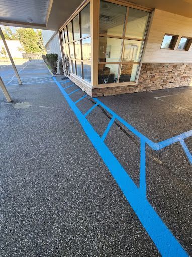 A blue line is painted on the sidewalk in front of a building.