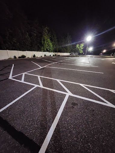 A parking lot with white lines painted on it at night.