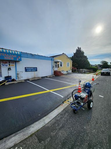 A machine is sitting in a parking lot in front of a building.