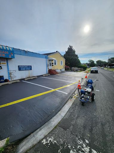 A machine is sitting on the side of the road next to a parking lot.