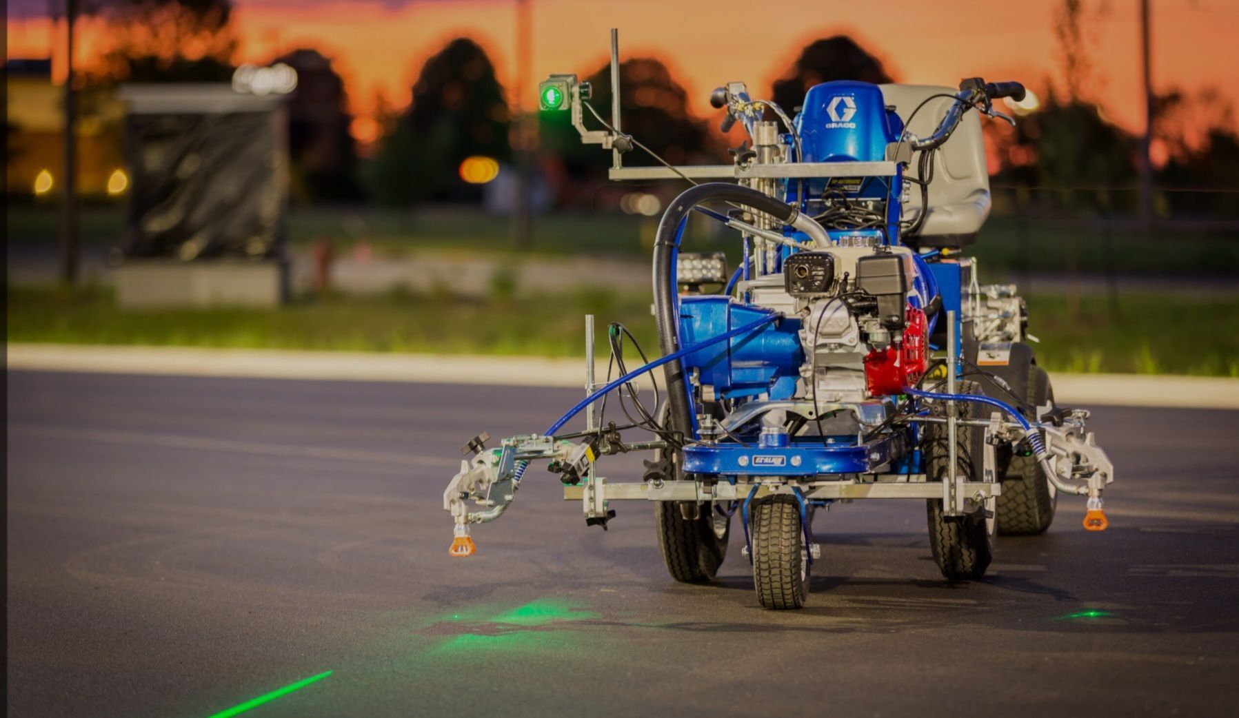 A machine is spraying white paint on a road