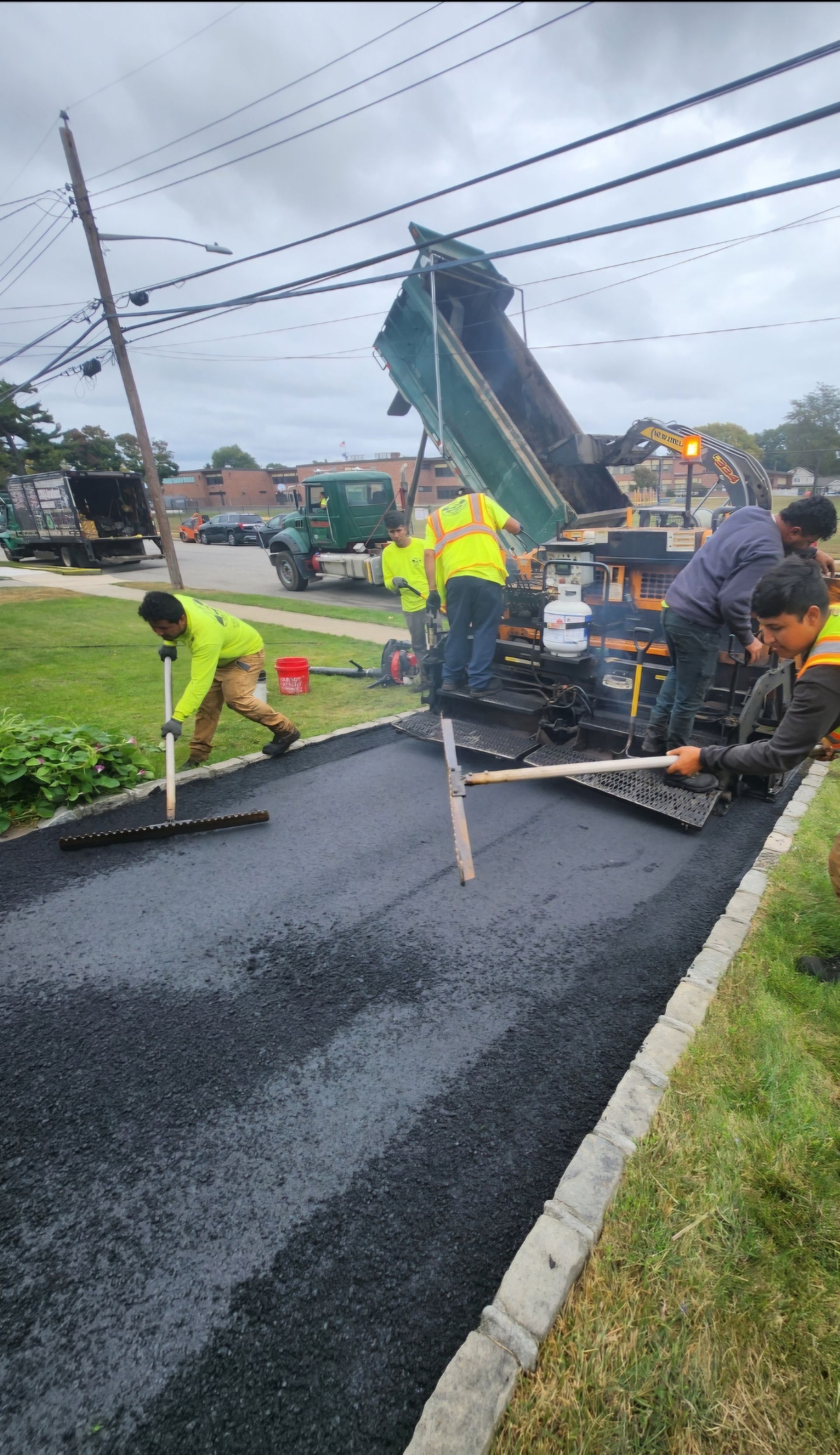 A truck is spraying asphalt on the side of a road