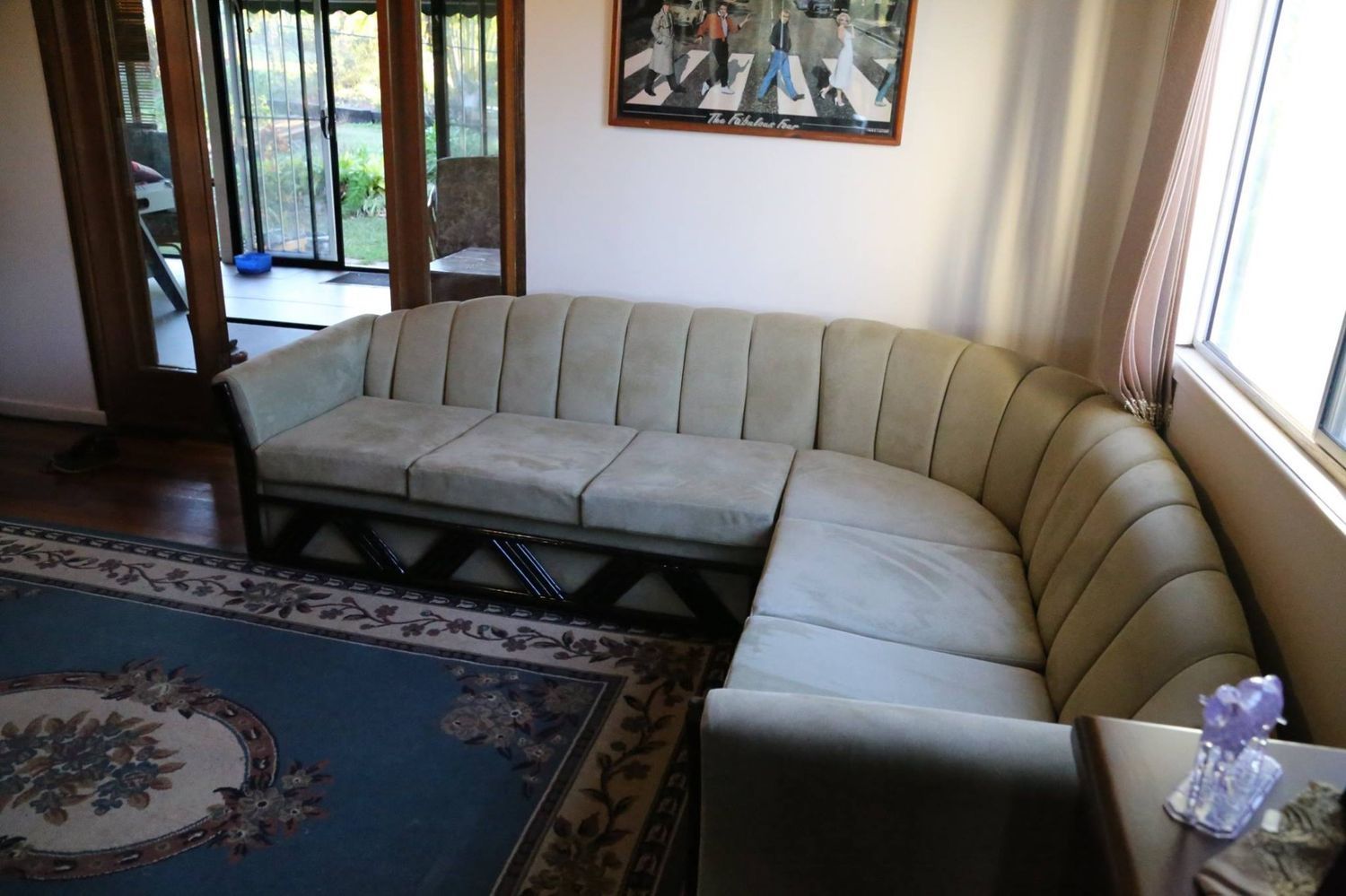 A Living Room With a Beige Sectional Sofa on a Blue Rug — McCormick Upholstery In Coolum Beach, QLD