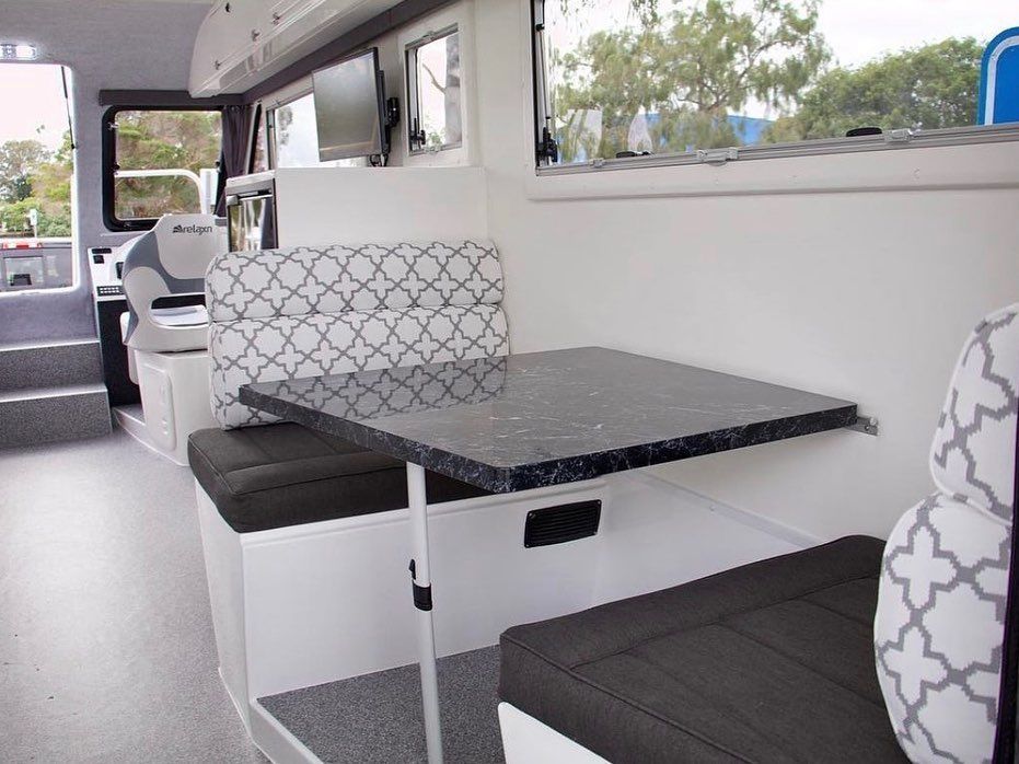 Interior of a Boat With a Table, Cushioned Seating, and Windows — McCormick Upholstery In Coolum Beach, QLD