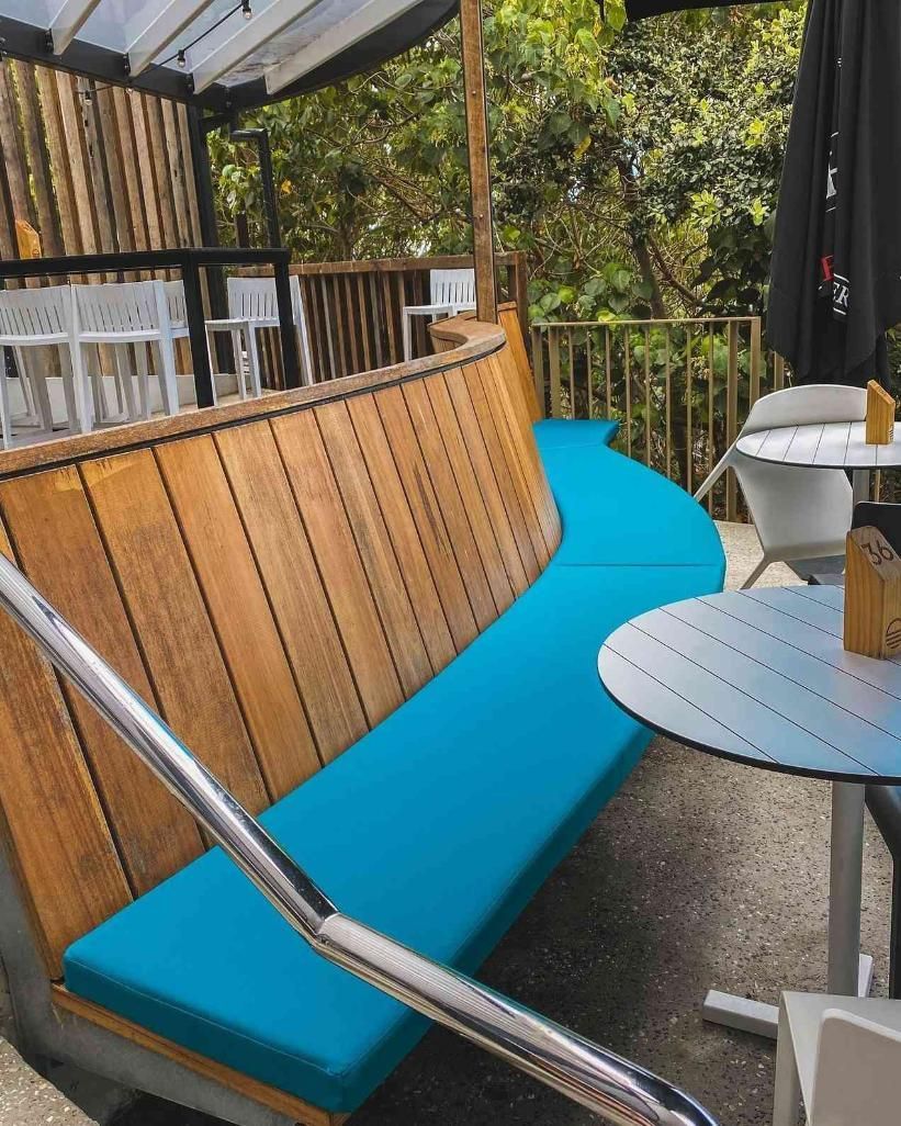 Outdoor Seating Area With a Curved Wooden Bench — McCormick Upholstery In Coolum Beach, QLD