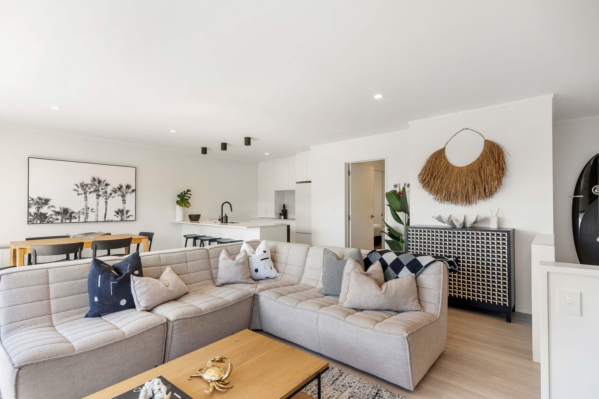 Modern living room with sectional sofa, dining table, and decorative wall art.