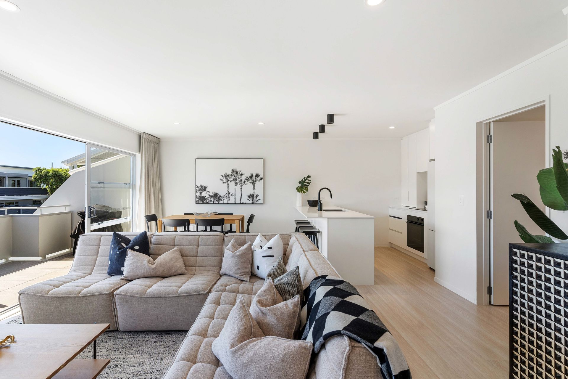 A living room with a couch , chairs , and a table.