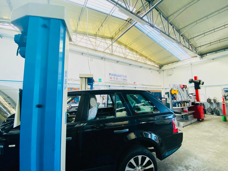 Un'auto nera è ferma sull'ascensore di un garage.