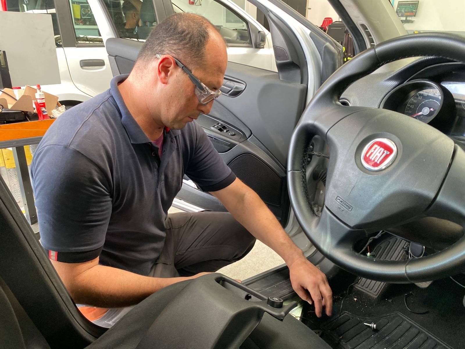 Un uomo sta lavorando agli interni di un'auto fiat.