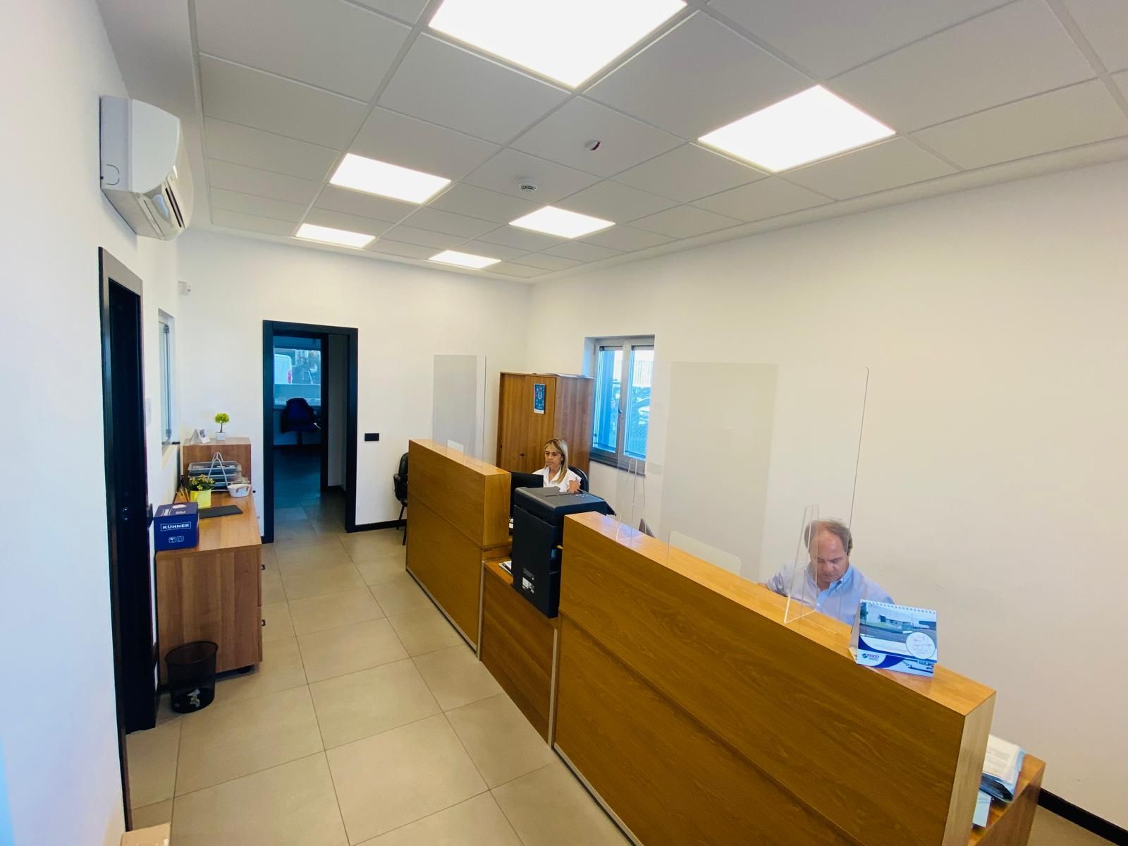 Un uomo e una donna sono seduti alla scrivania di un ufficio.