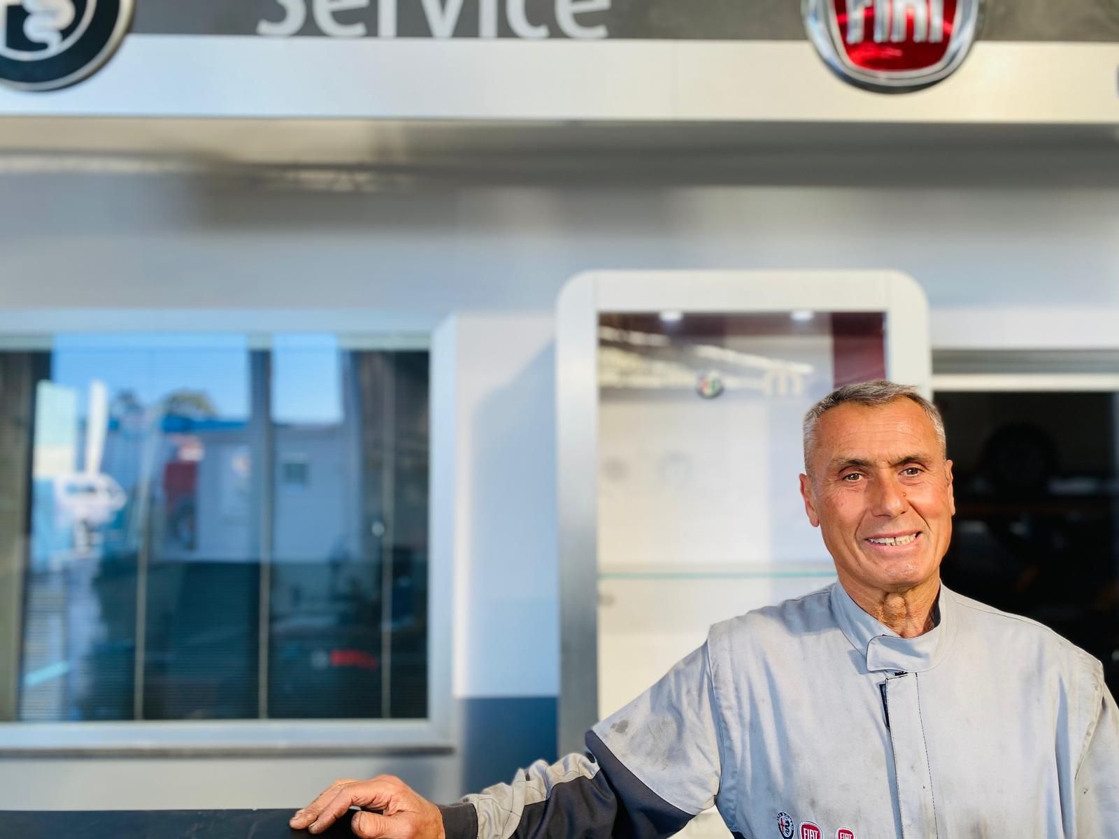 Un uomo è in piedi davanti a un cartello che dice servizio