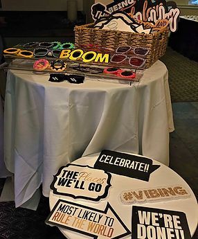 A table with photo booth props: sunglasses, signs saying
