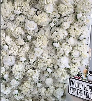 White flower wall backdrop, with roses and hydrangeas.