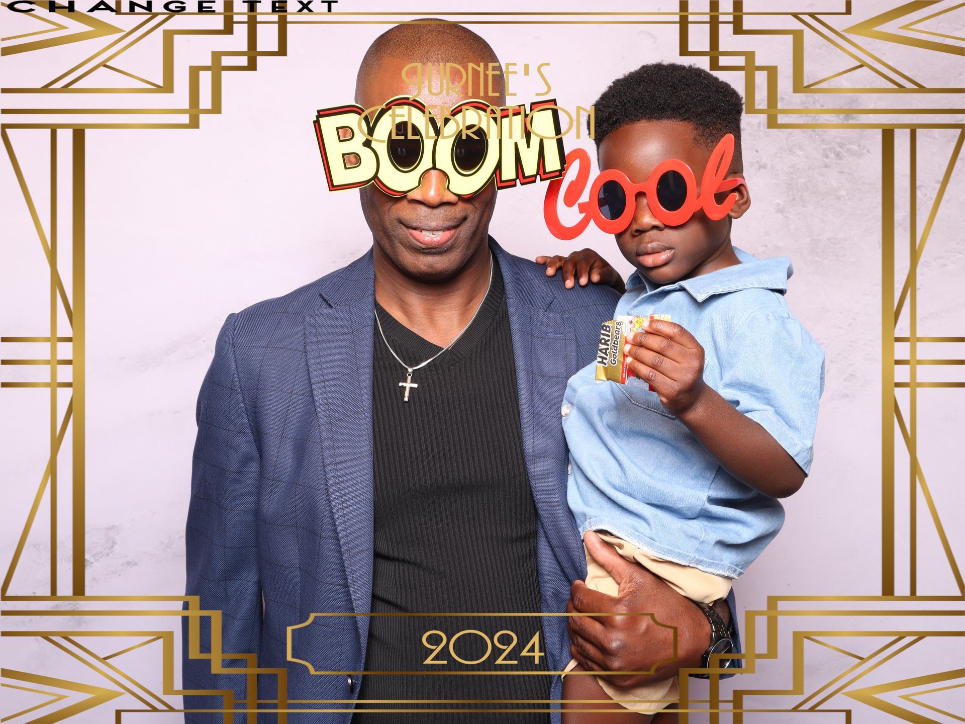 Father and son posing in a photo booth, both wearing novelty glasses. Gold accents and 2024 text are in the background.