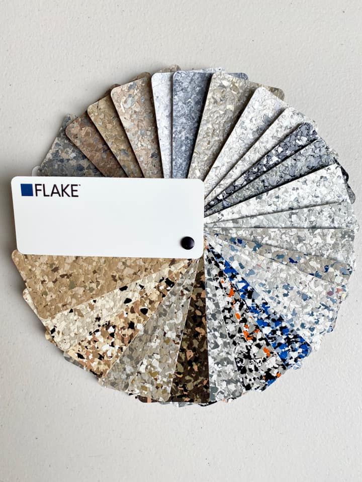 A fan deck of decorative vinyl paint flakes in various colors, textures, and patterns for flooring or surface applications.