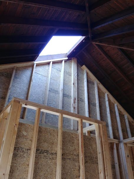 Interior view of wooden house frame with a skylight in the roof. Construction site.