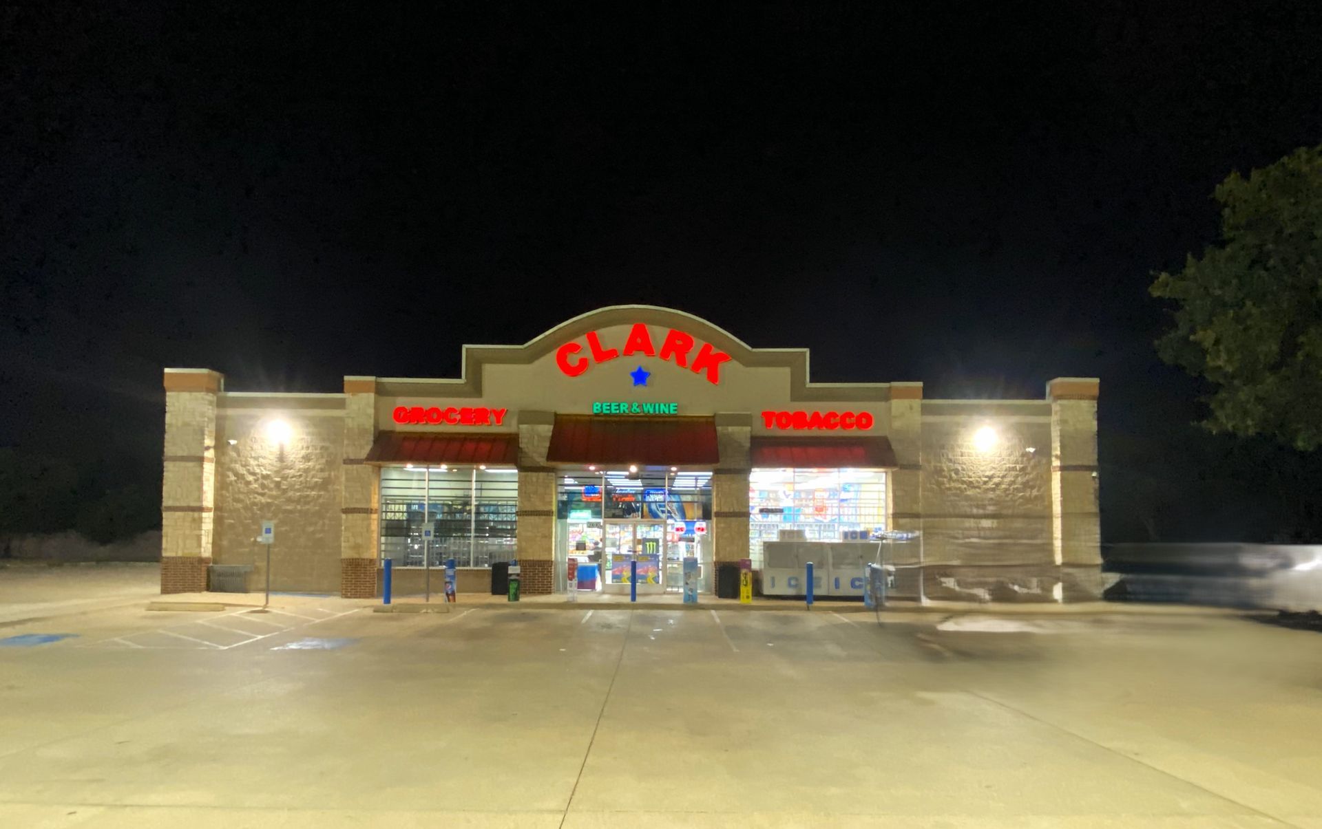 Clark convenience store at night, illuminated signs and entrance visible, dark sky above.