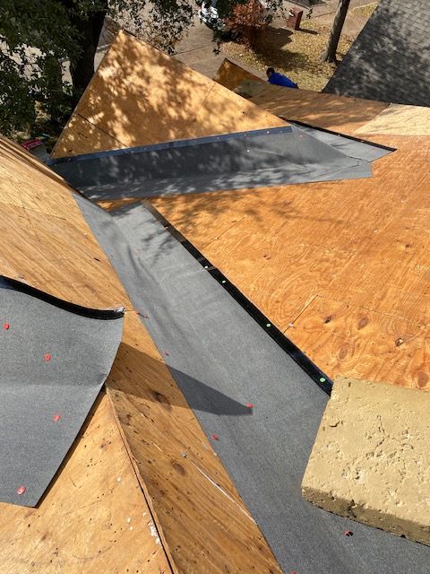 Roof under construction: plywood, black sealant, and a foam block.